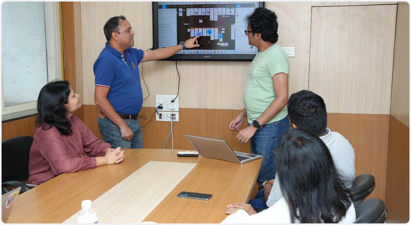 A CTutor team member presents the platform on a wall screen to colleagues around a meeting table