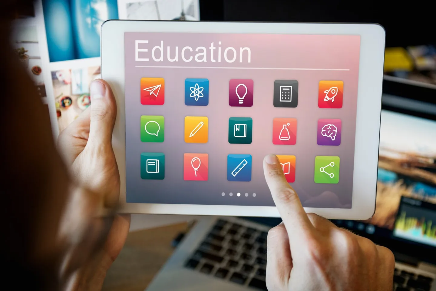 Hand tapping an education app on a tablet