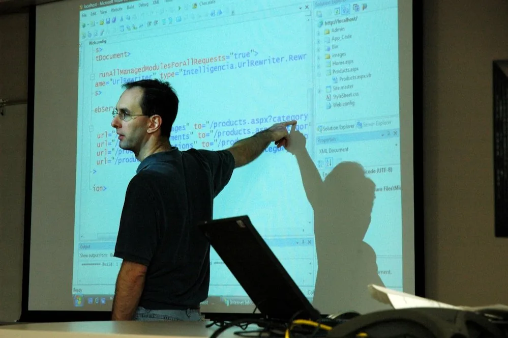 A tutor pointing at a diagram projected on a whiteboard