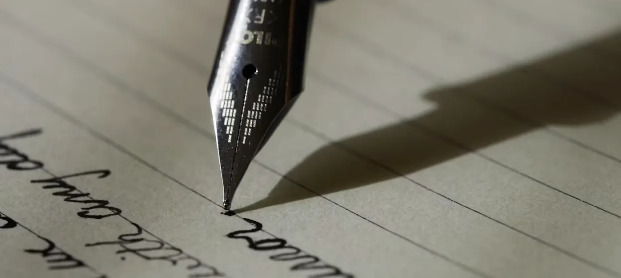 Fountain pen nib writing on lined paper